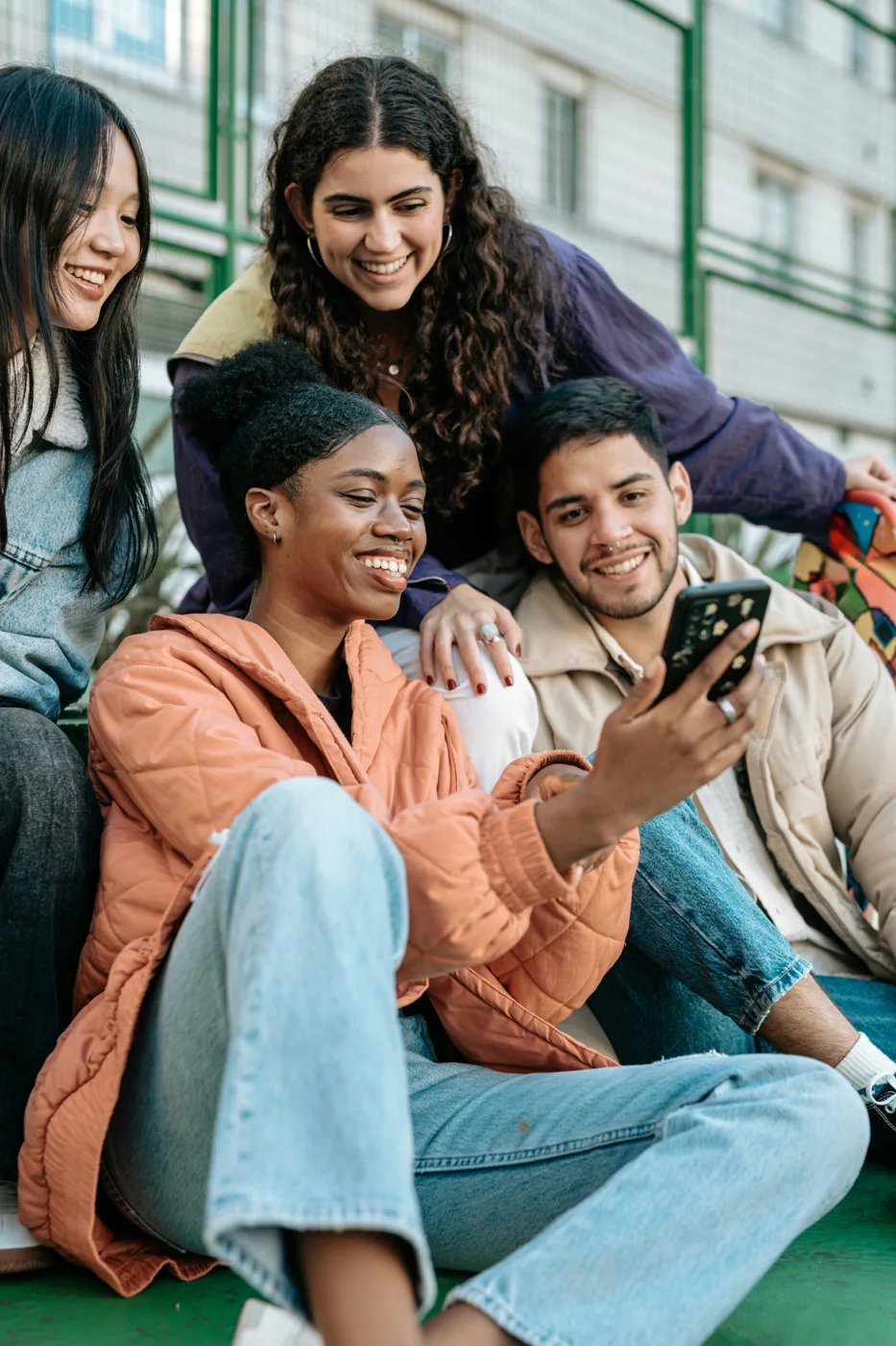 Four friends smiling at a phone together